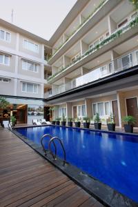 a swimming pool in front of a building at Ohana Hotel Kuta in Kuta
