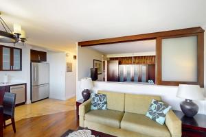 a living room with a couch and a kitchen at The Regency at Beachwalk - Unit 93 in Honolulu