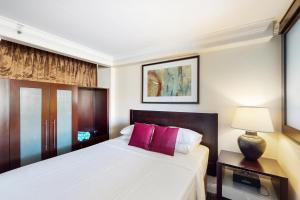 a bedroom with a large bed with red pillows at The Regency at Beachwalk - Unit 93 in Honolulu