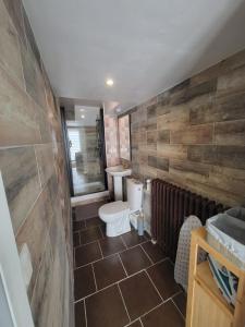 a bathroom with a white toilet and a brick wall at L'agréable in Nantes