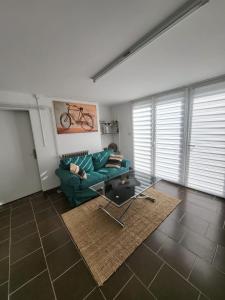 een woonkamer met een groene bank en een tafel bij L'agréable in Nantes