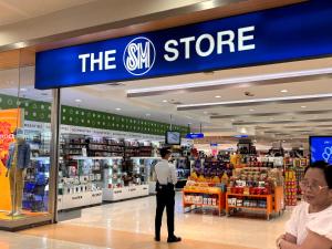 a man standing in front of the shop in a store at Condotel Minimalist in Marilao