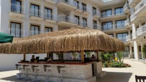 a bar with a straw roof in front of a building at Pasa Garden Beach in Marmaris