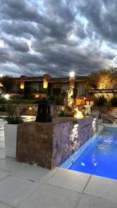 a swimming pool with a statue next to a house at Valle Las Piedras in Arroyo de Los Patos