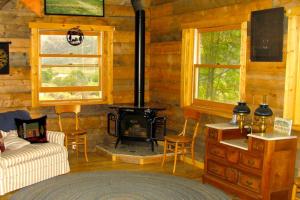 - un salon avec une cheminée dans une cabane en rondins dans l'établissement Peach Valley Retreat, à New Castle