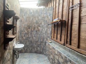 ein Badezimmer mit einem Waschbecken in einer Steinmauer in der Unterkunft Pucuk Bali Homestay in Canggu + 28 Fotos