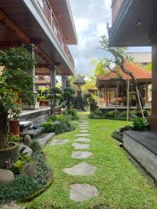 einen Gehweg durch einen Garten in einem Haus in der Unterkunft Pucuk Bali Homestay in Canggu