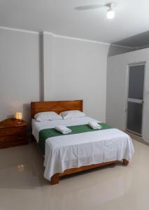 um quarto com uma cama com um cobertor verde e branco em Humazapa em Tarapoto