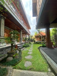 einen Garten vor einem Gebäude mit Gehweg in der Unterkunft Pucuk Bali Homestay in Canggu