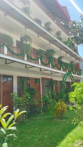 une maison avec un balcon orné de plantes. dans l'établissement Hospedaje Oxa Paraíso, à Oxapampa