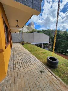 un neumático al lado de un edificio con una casa en Apartamentos da Rota, en Domingos Martins