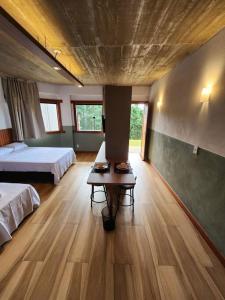 um quarto com duas camas e uma mesa em Apartamentos da Rota em Domingos Martins