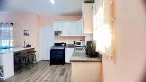 a kitchen with white cabinets and a counter top at Lulu cottage in Basse Terre Town