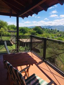 a deck with a wooden table and chairs on a balcony at Cañada Al Lago in Villa Parque Siquiman