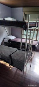 a room with two bunk beds and a chair at Hostel Aprisco Brasil in Sao Paulo