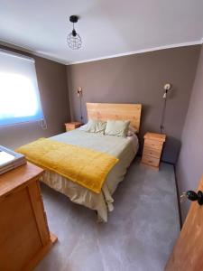 Un dormitorio con una cama con una manta amarilla. en Cabañas Sol de Vicuña en Vicuña