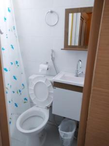 a bathroom with a toilet and a sink and a mirror at Hostel Aprisco Brasil in Sao Paulo