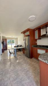 a large kitchen with a table and chairs in it at Comodo departamento en Playa el Angel in Pampatar