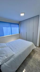 a bedroom with a bed and a large window at Comodo departamento en Playa el Angel in Pampatar