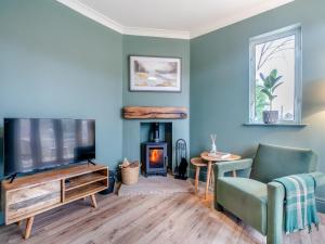 a living room with a fireplace and a tv at Highbury in Rothbury