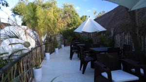 a row of tables and chairs with an umbrella at Cozy room near the beach, party zone in Tulum