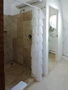 a shower in a bathroom with a shower curtain at Cozy room near the beach, party zone in Tulum