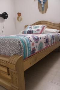 a bed with a wooden frame with a quilt on it at Genial Apto ubicacion estratégica in Medellín
