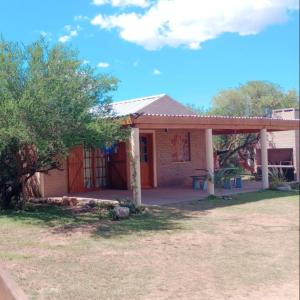 een klein huis met een veranda en een boom bij Rincón de Afrodita in San Lorenzo