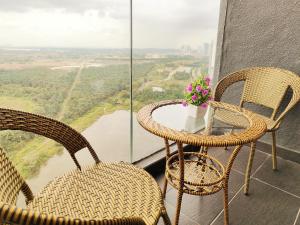 a balcony with two chairs and a table with flowers at ZUNCY T21 ,Legoland, Medini, BukitIndah in Nusajaya