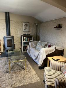 a living room with a bed and a tv at The Old Stable at Greatfield in Royal Wootton Bassett