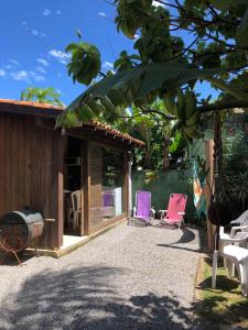 a patio with purple chairs and a house at Casinha Astral - Praia da Ferrugem in Garopaba