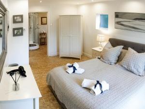 een slaapkamer met een bed met handdoeken erop bij The Old Pool House in Charlton Abbots