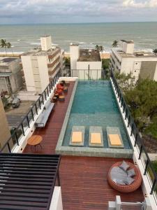 uma piscina no topo de um edifício com o oceano em Flat novíssimo GET ONE, a 2 passos da praia, João Pessoa em João Pessoa