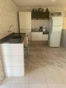 a kitchen with white cabinets and a refrigerator at Chácara Ohana in Mairinque