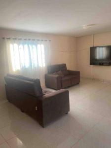 a living room with a couch and a flat screen tv at Chácara Ohana in Mairinque +16 photos