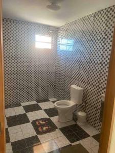 a bathroom with a toilet in a tiled floor at Chácara Ohana in Mairinque