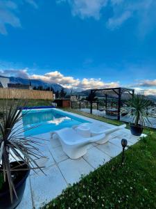 una piscina con una bañera blanca junto a una piscina en Refugio del Pescador en Esquel