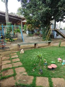 Sitio Cantinho da Alegria في كونفينس: حديقة بها ملعب مع زحليقة ومعدات لعب