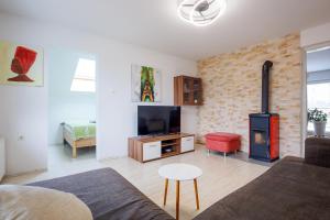 a living room with a fireplace and a couch and a tv at Rural Retreat - Comfort Oasis in Oplotnica