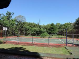 a tennis court with two tennis courts at Hotel Cabañas del Leñador in Puerto Iguazú