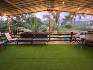 eine Terrasse mit 2 Bänken, einem Tisch und Stühlen in der Unterkunft Aeolus Guest House in José Pobre + 35 Fotos