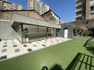 uma casa com um relvado verde no quintal em Like Home em Santiago