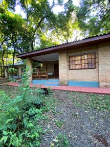 uma pequena casa com um telhado vermelho em Hotel Cabañas del Leñador em Puerto Iguazú
