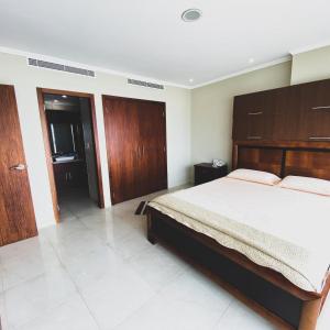 a bedroom with a large bed and wooden cabinets at Vista al río 502 riverfront in Guayaquil