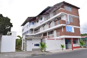 un bâtiment rouge et blanc sur le côté d'une rue dans l'établissement HOTEL SAN MARINO TUMACO, à Tumaco