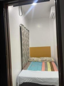 a small bed in a room with a mirror at Calo Apartel in Panabo