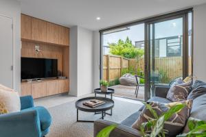 a living room with a couch and a tv at Urban Nest - Entire Townhouse and Free Parking in Christchurch