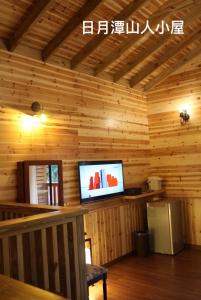 a living room with a television in a wooden house at Cabin of Sun Moon Lake in Yuchi