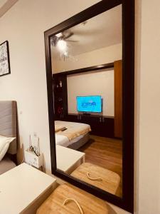 a mirror in a room with a bed and a television at Condo Suite Near JohnHay MinesView TheMansion in Baguio