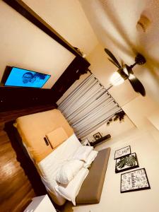 Condo Suite Near JohnHay MinesView TheMansion في باغيو: غرفة نوم مع سرير وتلفزيون بشاشة مسطحة